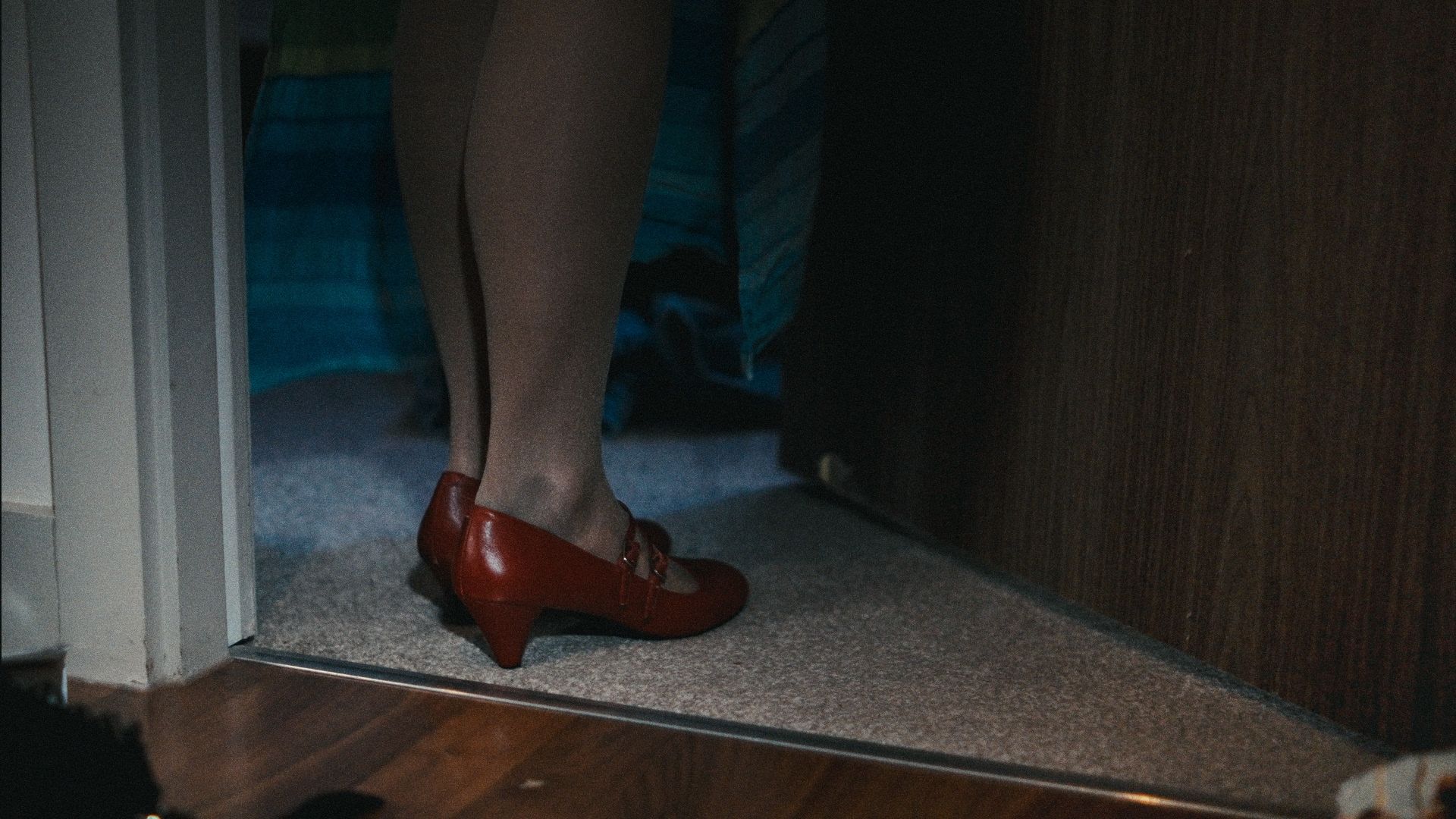 a mysterious woman in red shoes